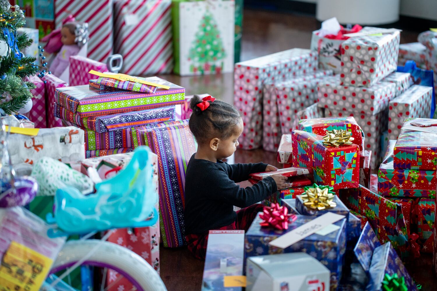 DeKalb County Sheriff’s Office holds the 16th annual Adopt-A-Family celebration on Tuesday, Dec 16, 2023 where 3-year-old Olivia Banks finds herself surrounded by gifts.. Law enforcement officers donate their own money and buy gifts for about a dozen local children.  (Jenni Girtman for The Atlanta Journal-Constitution)