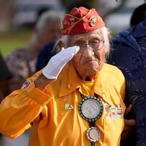 Navajo Code Talker Thomas Begay salutes during the national anthem during a ceremony on Navajo Code Talkers Day, Friday, Aug. 14, 2026, in Phoenix. (AP Photo/Ross D. Franklin)