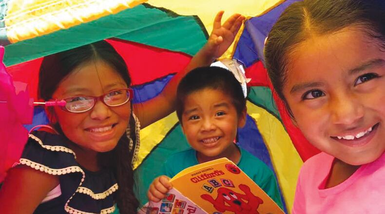 Students (from left) Roxana Carrillo-Acevedo and Juan and Diana Arroyo-Gutierrez read together at the summer reading program of the Oak Grove Elementary Fine Arts Academy. The Cherokee County Schools plans to introduce a pilot program to register students digitally, rather than by paper, this winter. CHEROKEE COUNTY SCHOOLS