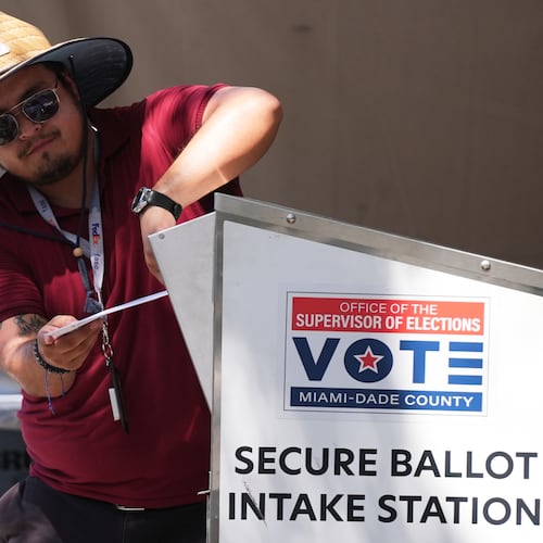 An election worker places a vote-by-mail ballot into a secure bin at the Miami-Dade County Supervisor of Elections Office during the Florida primary election in Doral, Fla., Tuesday, Aug. 18, 2026. (AP Photo/Lynne Sladky)