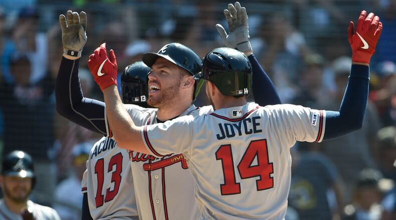 Freddie Freeman is congratulated by Matt Joyce #14 and Ronald Acuna Jr. #13 after hitting a three-run home run during the eighth inning of a baseball game against the San Diego Padres at Petco Park on July 14, 2019 in San Diego, California. (Photo by Denis Poroy/Getty Images)