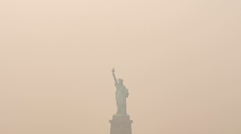 The Statue of Liberty is photographed from the Staten Island Ferry as smoke from wildfires blankets the sky, Thursday, July 16, 2026, in New York. (AP Photo/Yuki Iwamura)