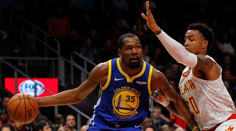 Kevin Durant drives against John Collins during Monday's game at State Farm Arena. (Photo by Kevin C. Cox/Getty Images)