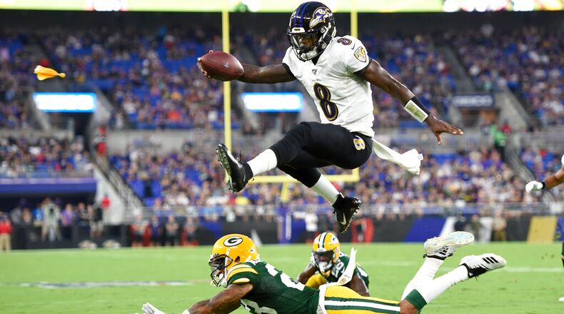 Baltimore Ravens quarterback Lamar Jackson leaps over Green Bay Packers cornerback Jaire Alexander. AP file photo