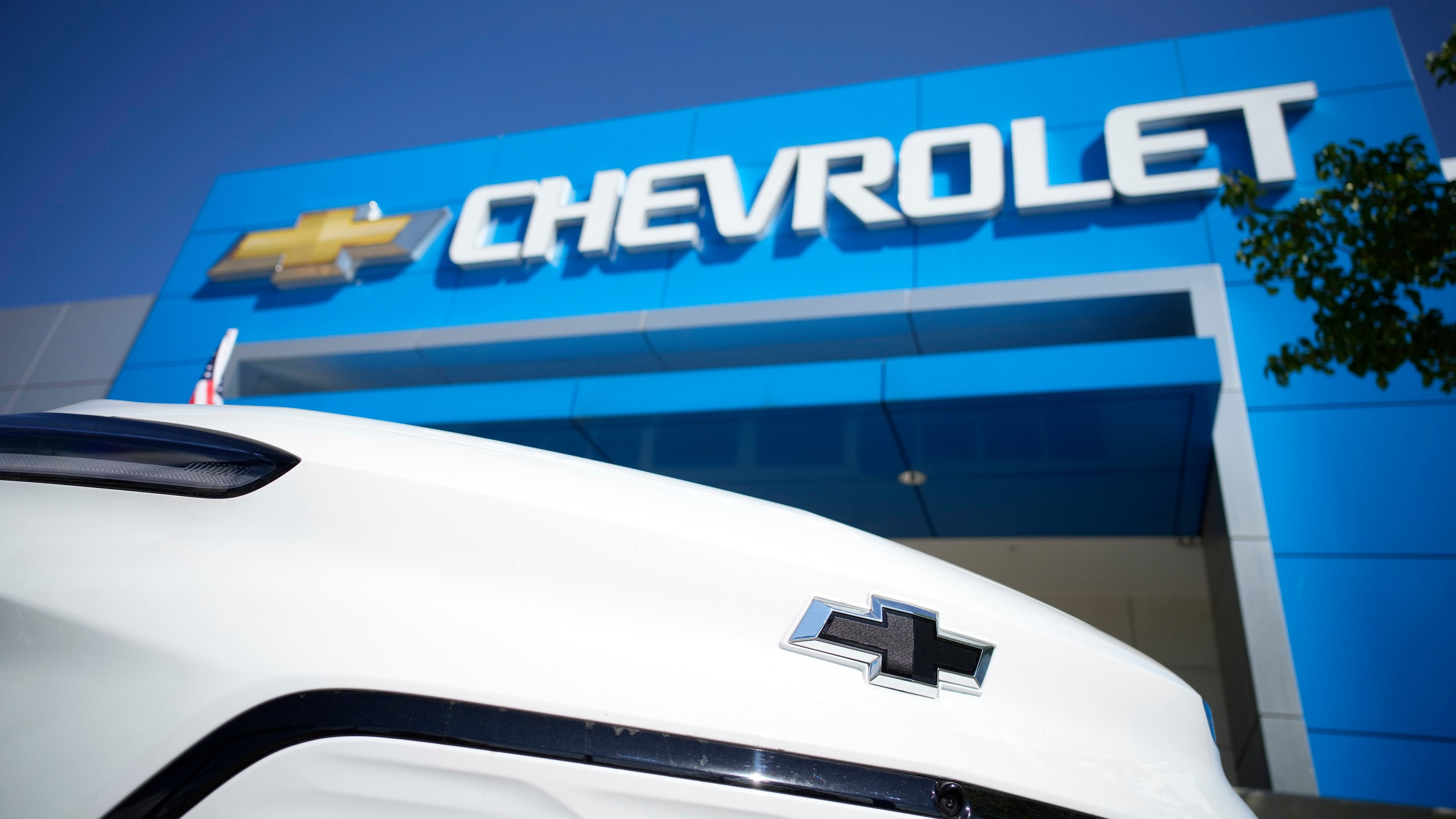 FILE - The company logo shines off the nose of an unsold 2022 Bolt electric vehicle on display in front of a Chevrolet dealership Sunday, Sept. 12, 2021, in Englewood, Colo. (AP Photo/David Zalubowski, File)