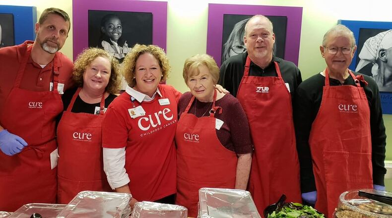 Karen Rutherford (third from left) and members of her family gather for a photo last year at Children’s Healthcare of Atlanta at Egleston. The Rutherfords volunteer annually to help serve Thanksgiving dinner to children with cancer and their families who are unable to be at home. CONTRIBUTED