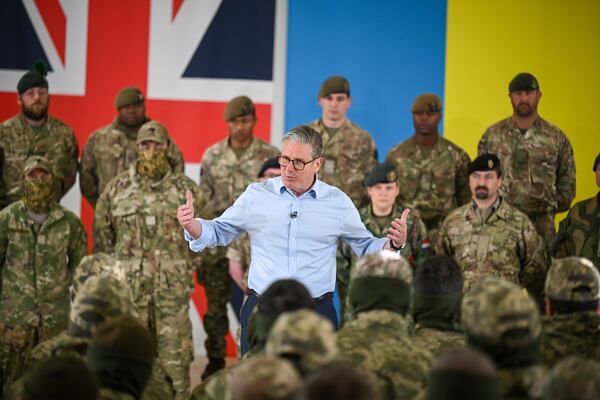 Britain's Prime Minister Keir Starmer, center, speaks to troops during a visit to a military base training Ukrainian troops with New Zealand's Prime Minister Christopher Luxon, in the west of England, Tuesday, April 22, 2025. (Finnbarr Webster/Pool Photo via AP)