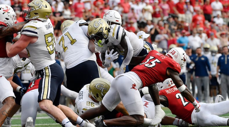 Georgia Tech running back Jamal Haynes, center, leaps over the line past the block of left tackle Jordan Brown (71) to score during the first half of an NCAA college football game in Louisville, Ky., Saturday, Sept. 21, 2024. (AP Photo/Timothy D. Easley)