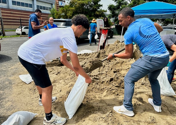 Volunteers fill sandbags for New Orleans residents, Wednesday, July 16, 2025, anticipating heavy rain from a tropical weather system moving toward the Gulf Coast. (AP Photo/Stephen Smith)