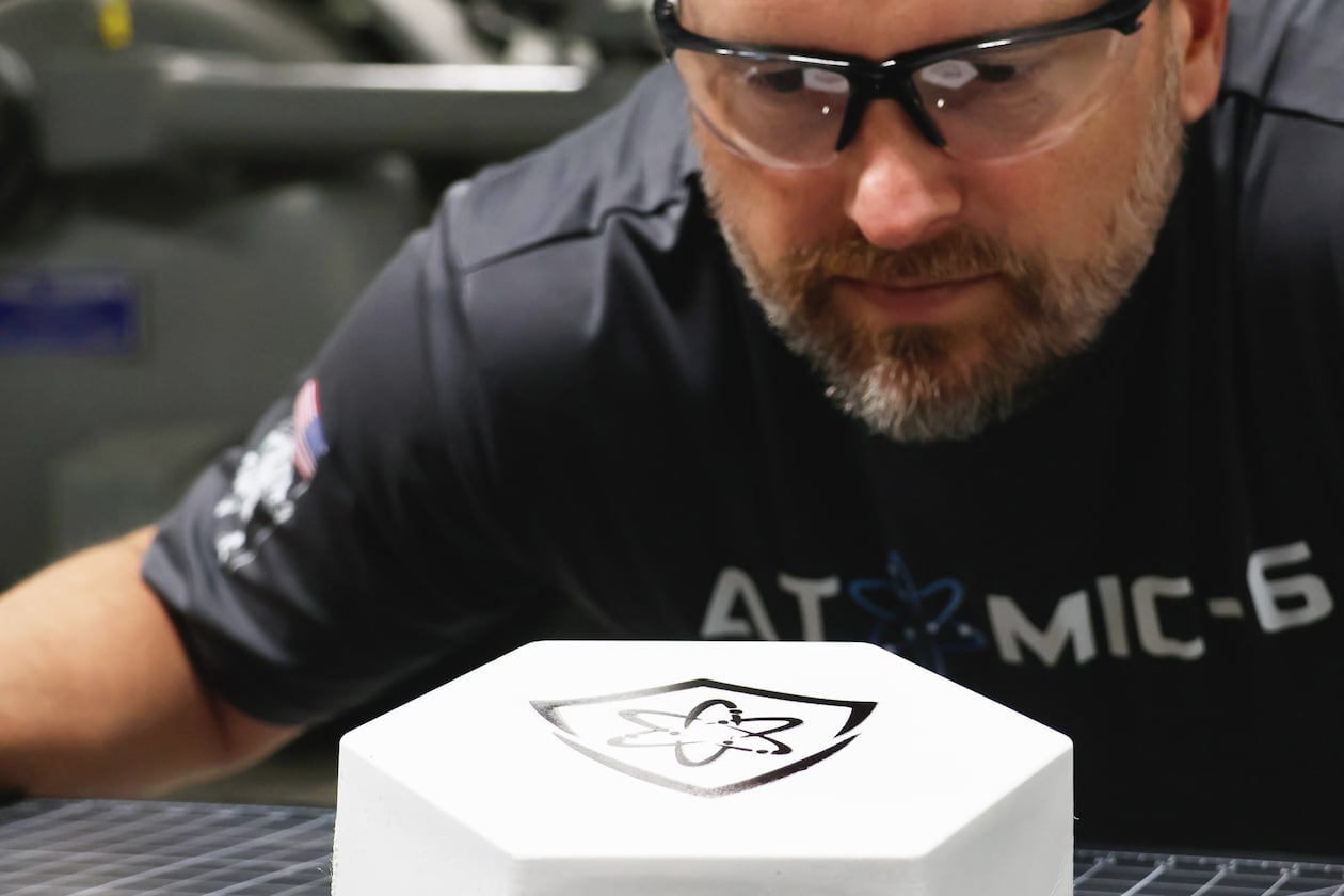 An inspector examines an Atomic-6 Space Armor tile, which is lighter than what is used today. (Courtesy of Atomic-6)