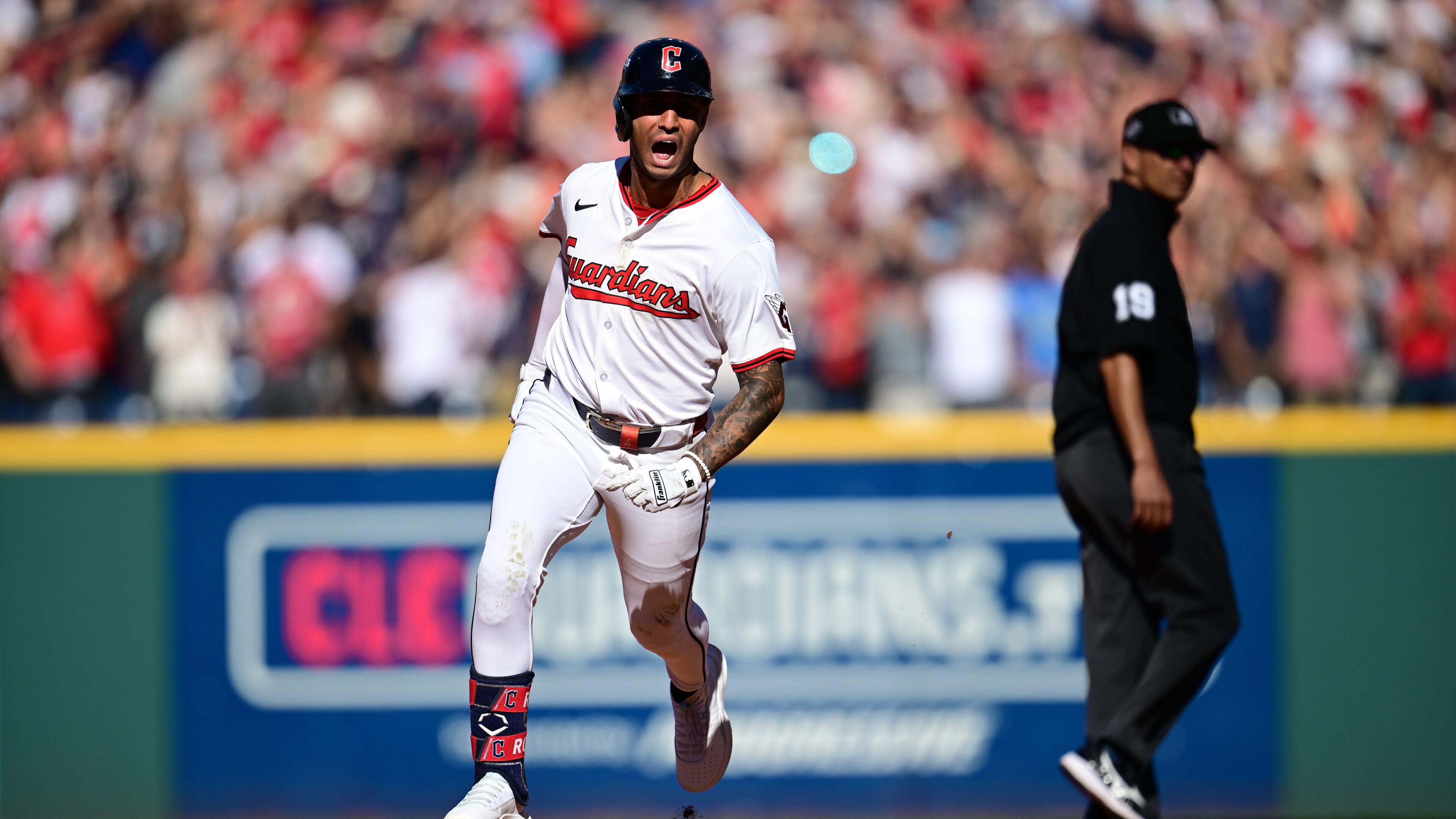 Cleveland Guardians Brayan Rocchio reacts as he rounds the bases after hitting a solo home run in the eighth inning of Game 2 of the American League Wild Card baseball playoff series against the Detroit Tigers in Cleveland, Wednesday, Oct. 1, 2025. Umpire Vic Carapazza looks on at right. (AP Photo/David Dermer)