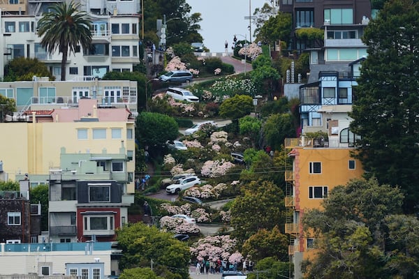 FILE - Cars and pedestrians move along crooked Lombard Street in San Francisco on Thursday, July 3, 2025. (AP Photo/Jeff Chiu, File)
