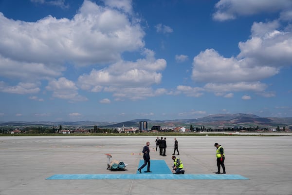 Airport workers prepare a carpet before arrival of Ukrainian President Volodymyr Zelenskyy at Esenboga airport in Ankara, Turkey, Thursday, May 15, 2025. (AP Photo/Evgeniy Maloletka)