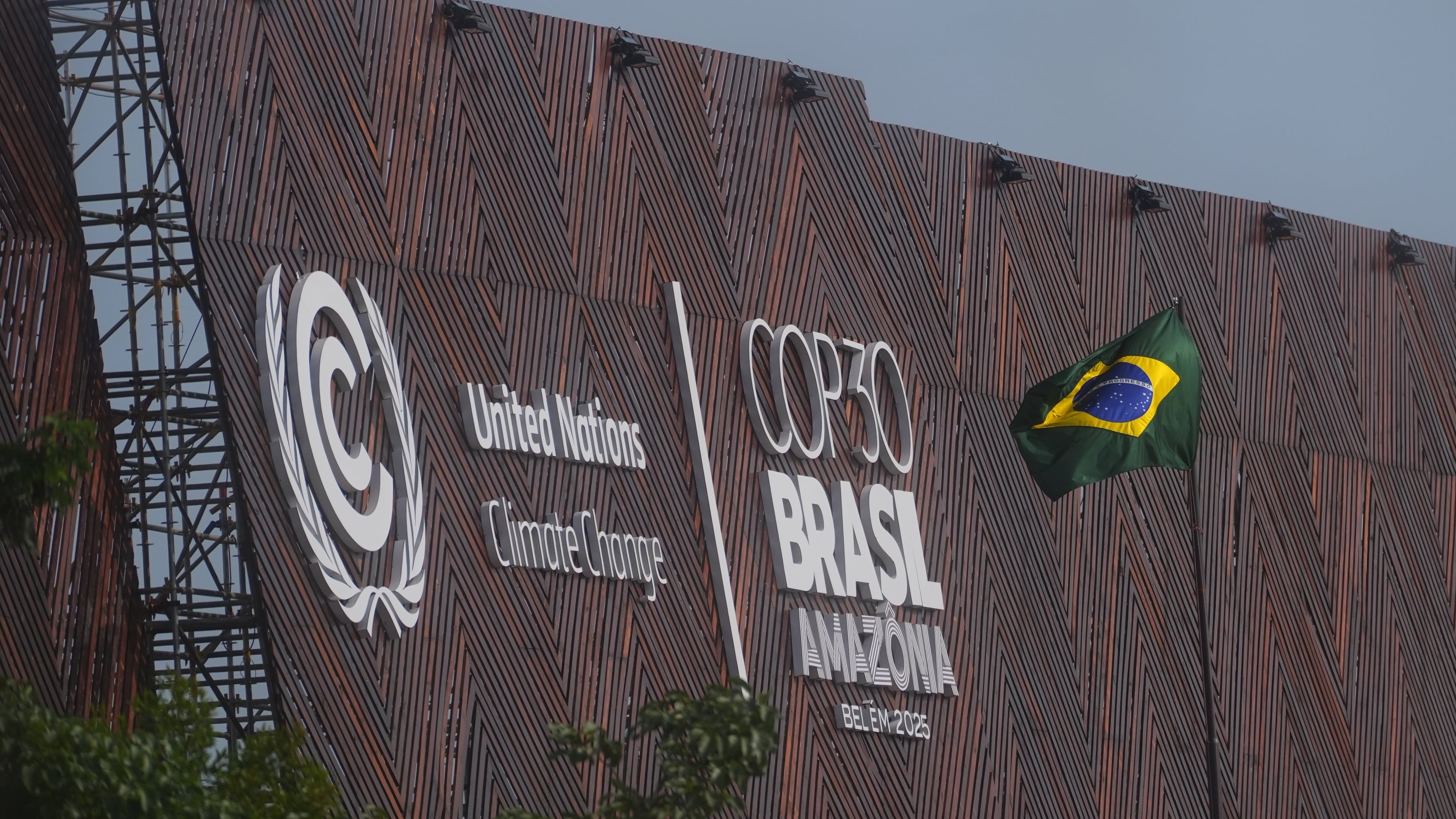 A Brazilian flag flies outside the venue for the COP30 U.N. Climate Summit, Thursday, Nov. 13, 2025, in Belem, Brazil. (AP Photo/Joshua A. Bickel)