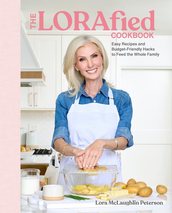 Lora McLaughlin Peterson stand in front of a kitchen counter on the cover of her debut cookbook, The LORAfied Cookbook.