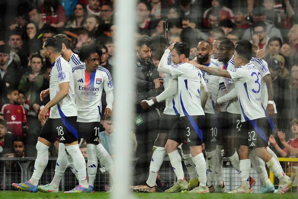 Lyon's Nicolas Tagliafico, center, celebrates with team mates after scoring his side's second goal during the Europa League quarter final second leg soccer match between Manchester United and Olympique Lyon in Manchester, Britain, Thursday, April 17, 2025. (AP Photo/Jon Super)