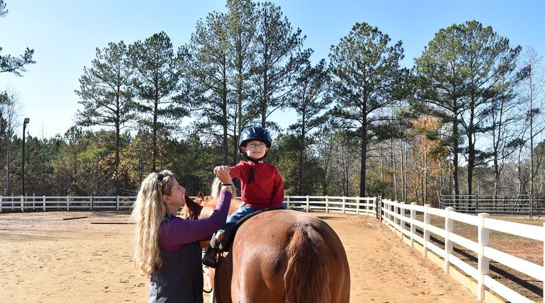 Jessica Moore works with 3-year-old Greyson O’Conor. Moore is the founder of a nonprofit that uses equine therapy to help children with special needs. CONTRIBUTED