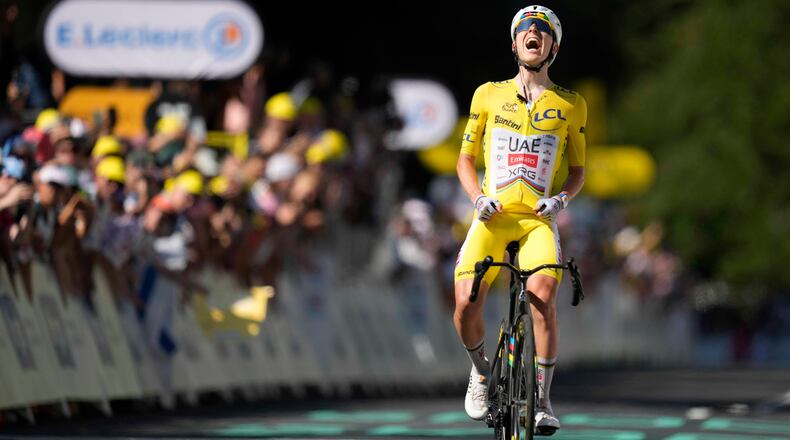 Slovenia's Tadej Pogacar, wearing the overall leader's yellow jersey, celebrates after winning the tenth stage of the Tour de France cycling race with start in Aurillac and finish in Le Lioran, France, Tuesday, July 14, 2026. (AP Photo/Mosa'ab Elshamy)