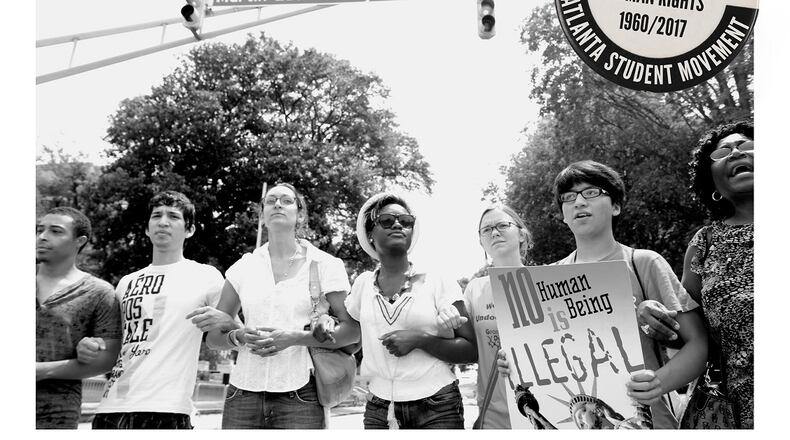 In this photo/graphic provided by the authors of the “New Appeal for Human Rights,” student activists are blocking an intersection in Atlanta as part of a protest advocating for unauthorized immigrant student access to higher education.
