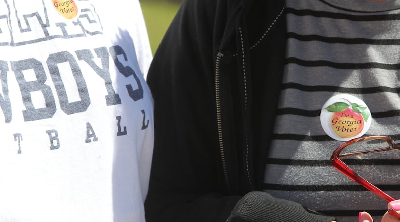 Voters brandish the stickers they are distributed after having voted in any election in the state of Georgia after casting their vote in the 6th District special election to replace Tom Price in Marietta, Georgia, on April 10, 2017. (HENRY TAYLOR / HENRY.TAYLOR@AJC.COM)