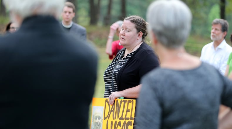 Mary Catherine Johnson, with Georgians for Alternatives to the Death Penalty, holds a photo of Daniel Anthony Lucas while leading a vigil outside of the Georgia Diagnostic and Classification State Prison in Jackson on Wednesday evening, April 27, 2016, at the time Lucas was scheduled to be executed for the 1998 murders of a Jones County father and his two children. (Ben Gray / bgray@ajc.com)