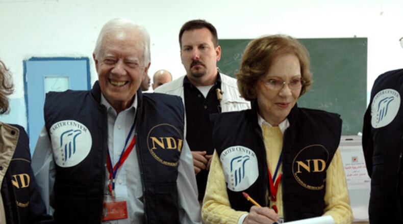 In this image released by the Carter Center, former U.S. President Jimmy Carter, left, and his wife Rosalyn smile as they visit a polling station during the Palestinian parliamentary elections in Arab east Jerusalem Wednesday Jan. 25, 2006. Nearly 20,000 local observers and 950 international monitors, led by Carter, watched the vote. (AP Photo/Deborah Hakes, The Carter Center)