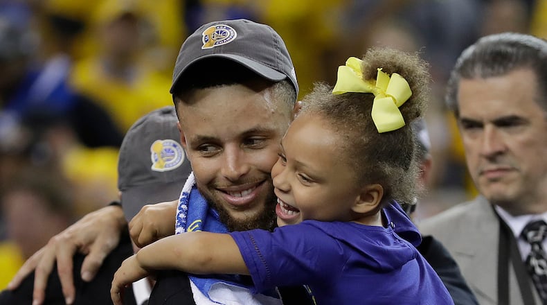 Golden State Warriors guard Stephen Curry hugs his daughter Riley after Game 5 of basketball's NBA Finals between the Warriors and the Cleveland Cavaliers in Oakland, Calif., Monday, June 12, 2017. The Warriors won 129-120 to win the NBA championship.