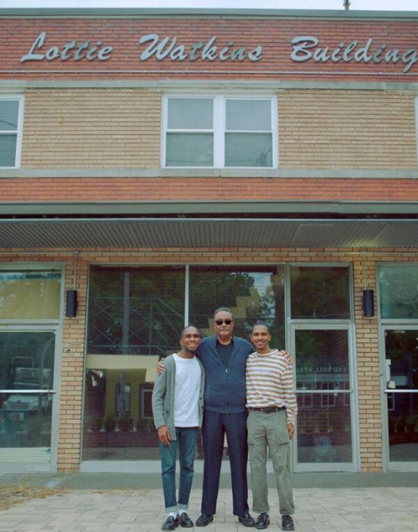 Portrait Coffee co-owner Aaron Fender (left) with Lottie Watkins' brother-in-law (center) and Portrait co-owner Marcus Hollinger (right) in front of the Lottie Watkins Building, home to Portrait Coffee. / Courtesy of Portrait Coffee