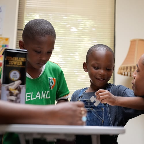 Derrick McNair-White, left, Malachi McNair-Nesbitt, and Elias Washington, right, do a puzzle together in family therapy on June 9, 2025, in Decatur, Ga. (AP Photo/Brynn Anderson)