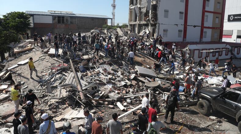 Residents and rescue workers search through the rubble of a collapsed building after an earthquake struck Cali, Colombia, Monday, Aug. 10, 2026. (AP Photo/Santiago Saldarriaga)