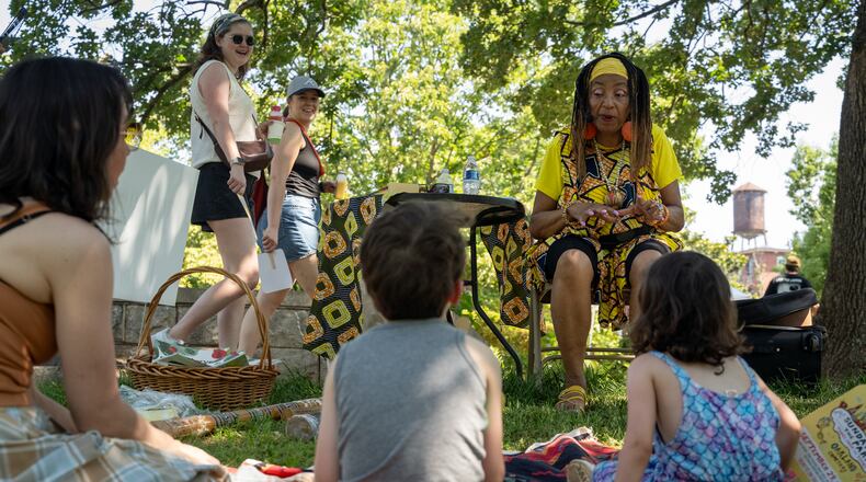 A mom and her two kids listen to a story. Atlanta residents celebrate at the Oakland Cemetary Juneteenth Family Festival. This is the third Juneteenth since becoming a federal holiday in 2021. Saturday, June 15, 2024 (Ben Hendren for the Atlanta Journal-Constitution)
