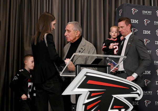 Falcons owner Arthur M. Blank (center) holds a hand of Sarah Ryan as the rest of the family (including husband Matt, new Falcons president of football) looks on following a news conference.