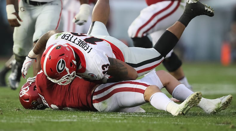 January 1, 2018 Pasadena: Georgia defensive end Jonathan Ledbetter flatens Oklahoma quarterback Baker Mayfield during the second half in the College Football Playoff Semifinal at the Rose Bowl Game on Monday, January 1, 2018, in Pasadena. Curtis Compton/ccompton@ajc.com