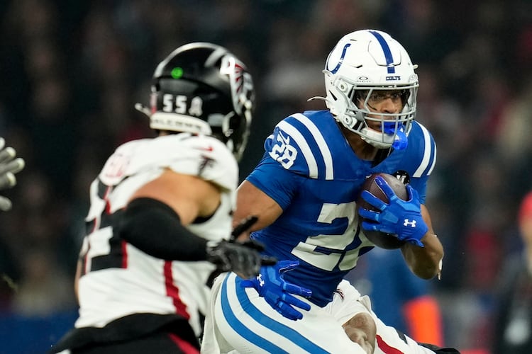 Indianapolis Colts running back Jonathan Taylor (28) runs from Atlanta Falcons linebacker Kaden Elliss (55) during the first half of an NFL football game, Sunday, Nov. 9, 2025, in Berlin, Germany. (AP Photo/Ebrahim Noorozi)