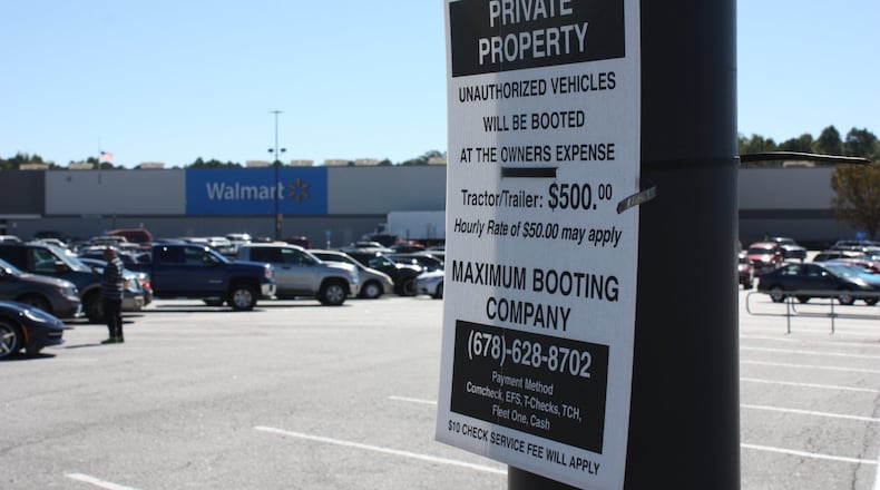 Signs in the Newnan Crossing shopping center in Newnan, Ga., warn owners of “unauthorized vehicles” they are subject to booting.