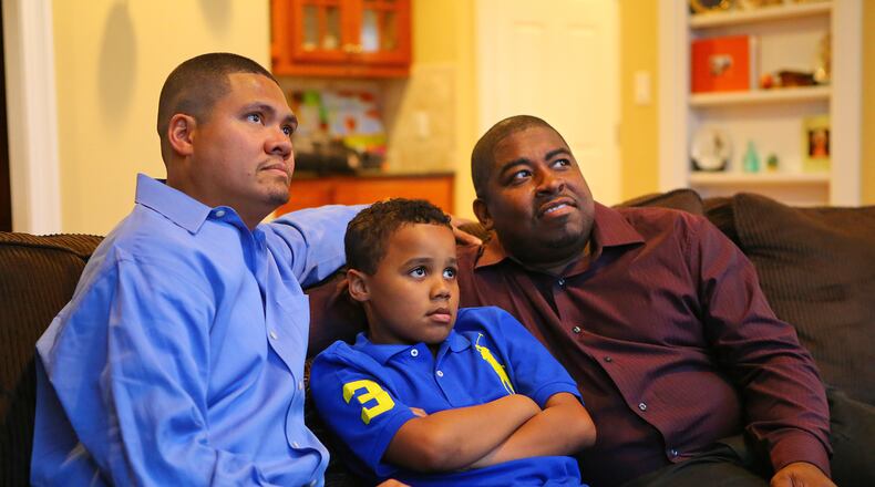 Chris Inniss (left) and Shelton Stroman watch TV with their son Jonathan, 9, in the living room of their home in Snellville. The couple are filing the first legal challenge to Georgia's ban on same-sex marriage.