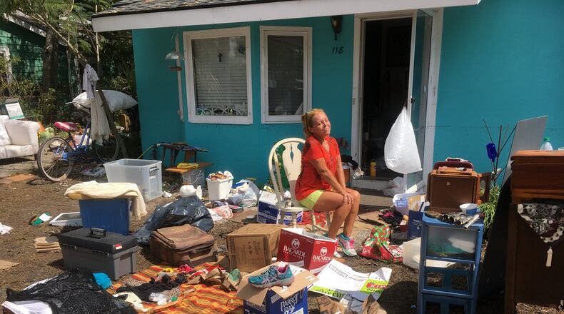 Jill Ebrecht has a huge cleanup job ahead of her following flooding from Tropical Storm Irma. She had been holding up pretty well until she came across a small cat figurine, a gift from her late husband, Rick. Its damage broke her heart. “He was so kind, so warm,” she said, wiping away tears on a blazing hot Thursday afternoon. She was glad to find priceless heirlooms like her great grandfather’s christening gown. His diary, she hoped, was among the waterlogged wreckage. Photo: Jennifer Brett, jbrett@ajc.com