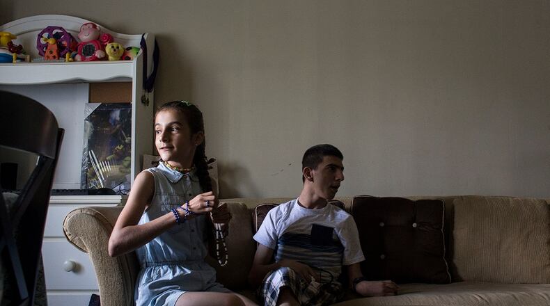 Nawroz Youssef and her brother, Alan, waiting for dinner in their Decatur home. Their Kurdish family fled Syria as refugees four years ago after Islamic State fighters invaded their town and started executing people. Chad Rhym/ Chad.Rhym@ajc.com