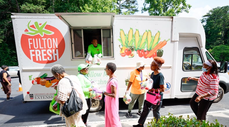 With the Fulton Fresh Mobile Market truck, Queante Jennings and Shirley Dodd (center) hand out free produce bags to St Mark AME Church nutrition class attendees on Tuesday, June 18, 2024. The area is considered a “food desert” because there are no grocery stores.
(Miguel Martinez / AJC)
