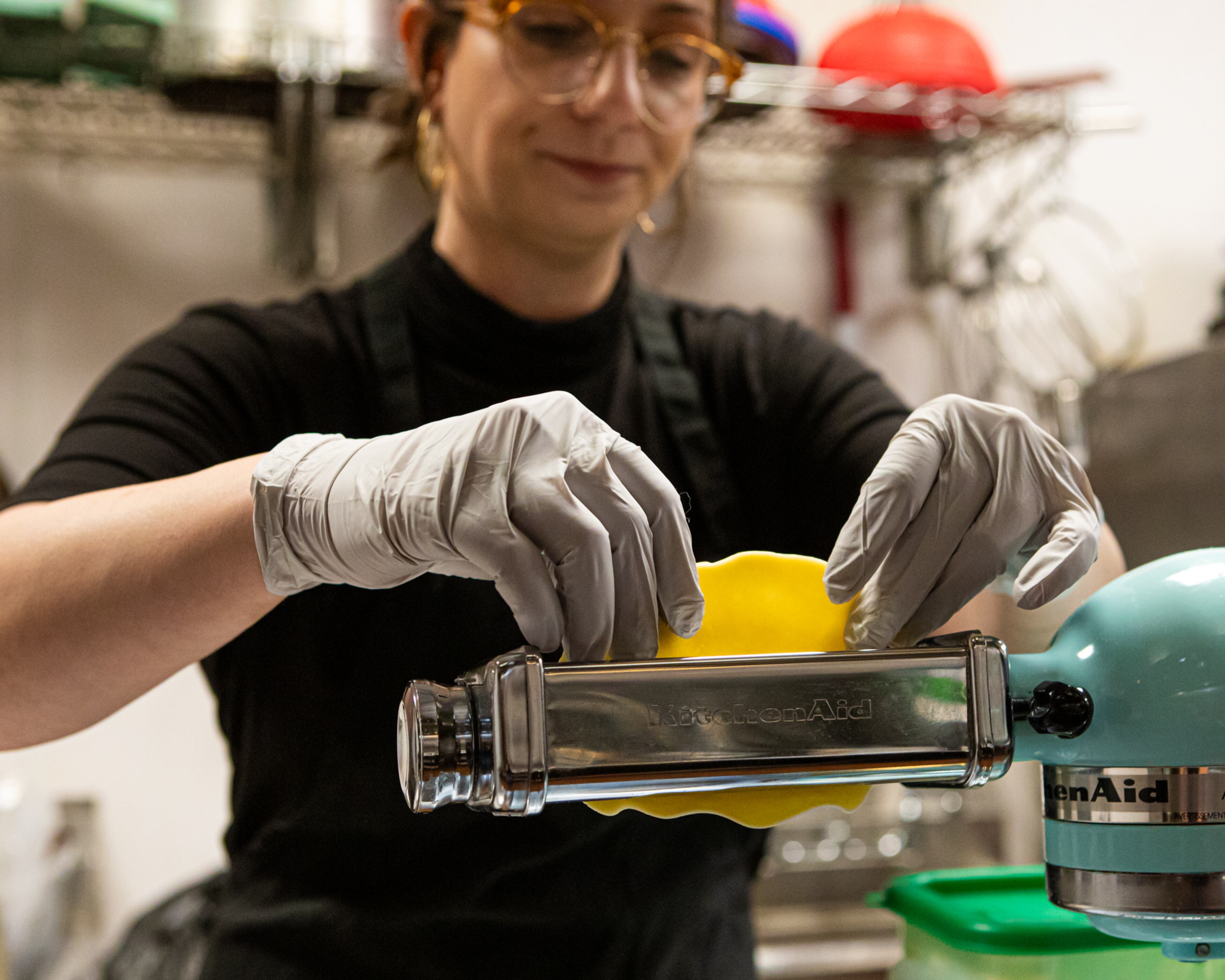 Basia Piechoczek runs pierogi dough through the pasta attachment of a stand mixer. Though it resembles pasta dough, pierogi dough contains butter and sour cream in addition to flour, water and eggs. (Aaliyah Man for the AJC)