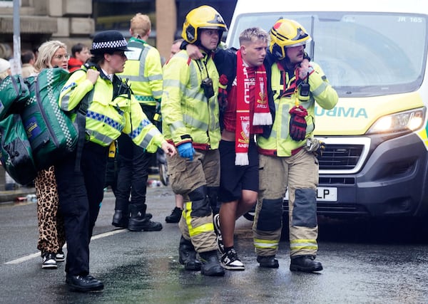 Police and emergency personnel deal with a road traffic accident on Water Street near the Liver Building in Liverpool after a car collided with pedestrians during the Premier League winners parade, in Liverpool, England, Monday May 26, 2025. (Owen Humphreys/PA via AP)