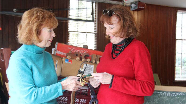 Sandy Springs Society volunteer Maidee Spencer (r) looks over items being donated by Jan Collins for the organization's upcoming Tossed Out Treasures sale.
