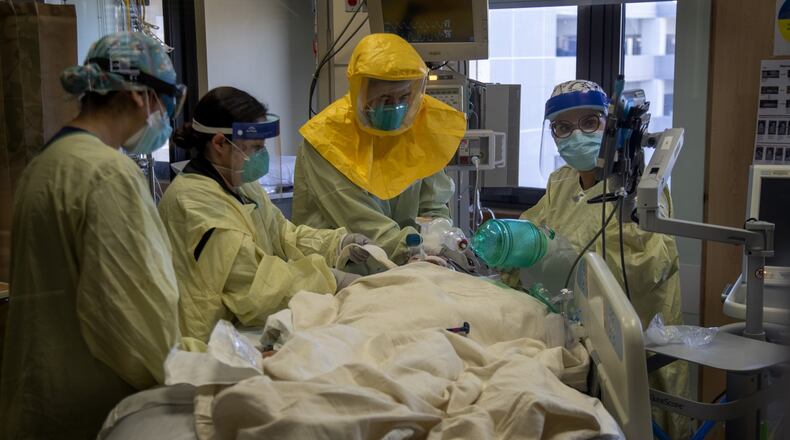 Pulmonologist Dr. Laren Tan, center, with his medical team of nurses and respiratory therapists intubate a COVID-19 patient who's oxygen levels were dropping in the ICU at Loma Linda University Medical Center on December 15, 2020 in Loma Linda, California. The hospital is experiencing a huge surge in COVID-19 patients. (Gina Ferazzi/Los Angeles Times/TNS)