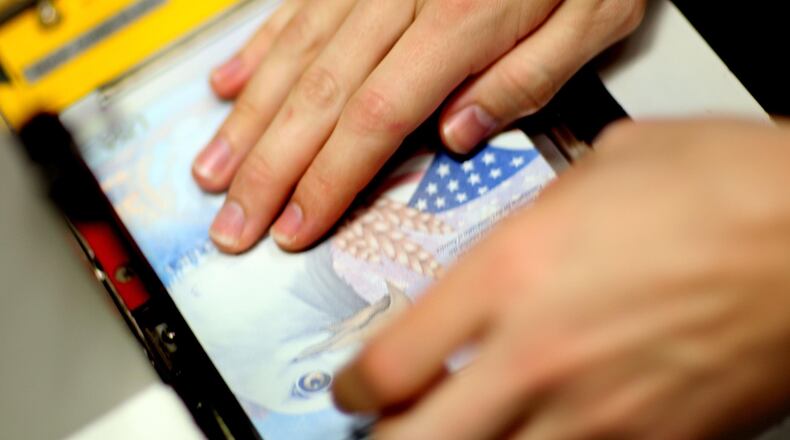 A Passport Processing employee prints a new passport at the Miami Passport Agency June 22, 2007 in Miami, Florida. (Photo by Joe Raedle/Getty Images)