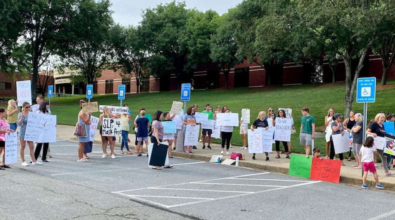 A group demonstrated Thursday, July 21, 2022, against a mask requirement for employees of Gwinnett County Public Schools. Gwinnett is at high risk for community transmission of COVID-19, according to the Centers for Disease Control and Prevention. That triggered the district mask requirement. (Josh Reyes / Josh.Reyes@ajc.com)