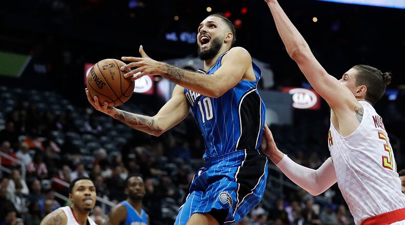 Orlando Magic’s Evan Fournier, left, of France, shoots against Atlanta Hawks’ Mike Muscala in the third quarter of an NBA basketball game in Atlanta, Tuesday, Dec. 13, 2016. Orlando won 131-120. (AP Photo/David Goldman)