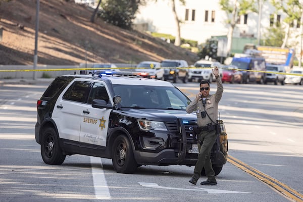 A sheriffs deputy monitors a street closure near the site of an explosion at the LA County Sheriff's Special Operations Bureau on Friday, July 18, 2025, in Los Angeles. (AP Photo/Etienne Laurent)
