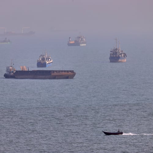 FILE - A small boat sails past cargo ships and other commercial vessels anchored in the Strait of Hormuz off Bandar Abbas, Iran, Wednesday, Aug. 5, 2026. (Amirhosein Khorgooi/ISNA via AP, File)