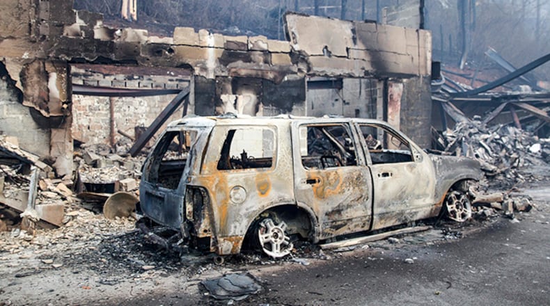A scorched vehicle sits next to a burned out building in Gatlinburg, Tenn., on Tuesday, Nov. 29, 2016. The fatal fires swept over the tourist town the night before, causing widespread damage. (AP Photo/Erik Schelzig)