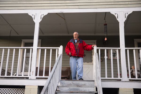 Marshall Edwards stands on his front porch of the Cabbagetown home that he shared with his brother Ronnie. (Jason Getz/AJC)